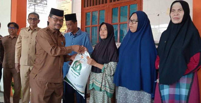 Plt Kepala Dinas Perdagangan,Koperasi & UKM saat menyalurkan beras bantuan pangan kepada keluarga rentan | doc | Deprindagkop |