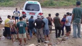 Warga menyebrangkan Ambulan menggunakan rakit darurat, Minggu (14/12) 