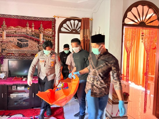 Personil Polres Gayo Lues sedang mengevakuasi jasad SH dari rumah kediamannya di Desa Raklunung, Sabtu (21/3/2026)
