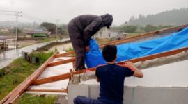 Personil Damkar sedang memasang tenda plastik pengganti seng diatap rumah warga, Rabu (15/4/2026)